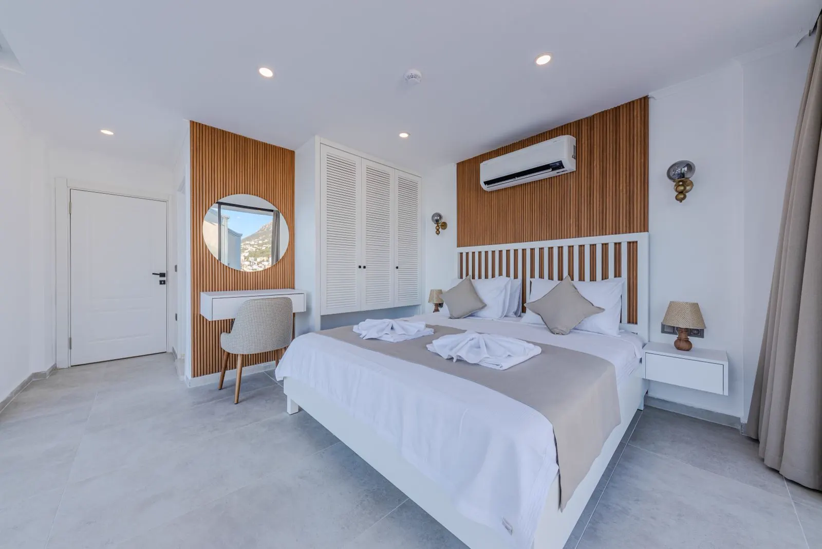 Helles Hotelzimmer mit weißen Wänden, Doppelbett und kleinem Schreibtisch